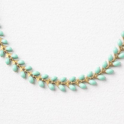 close up of seeds of hope necklace on a white background