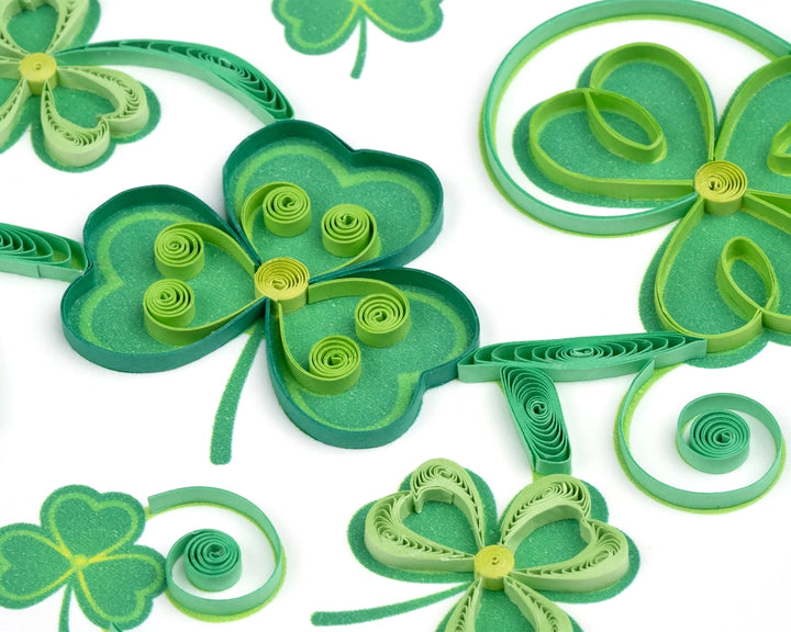 Quilled green shamrock decorations on a white background