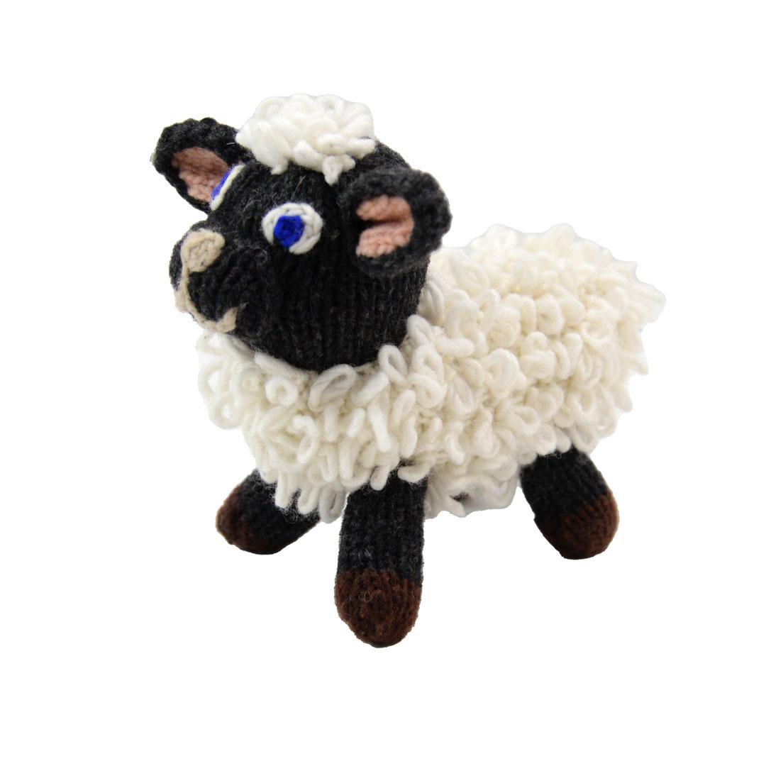 A handmade wool doll depicting a black and white sheep with a curly mane and tail.
