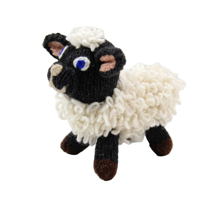 A handmade wool doll depicting a black and white sheep with a curly mane and tail.
