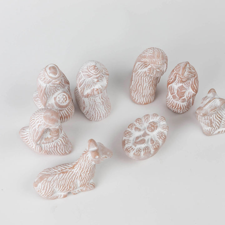 Collection of small ceramic animal figurines on a light gray background