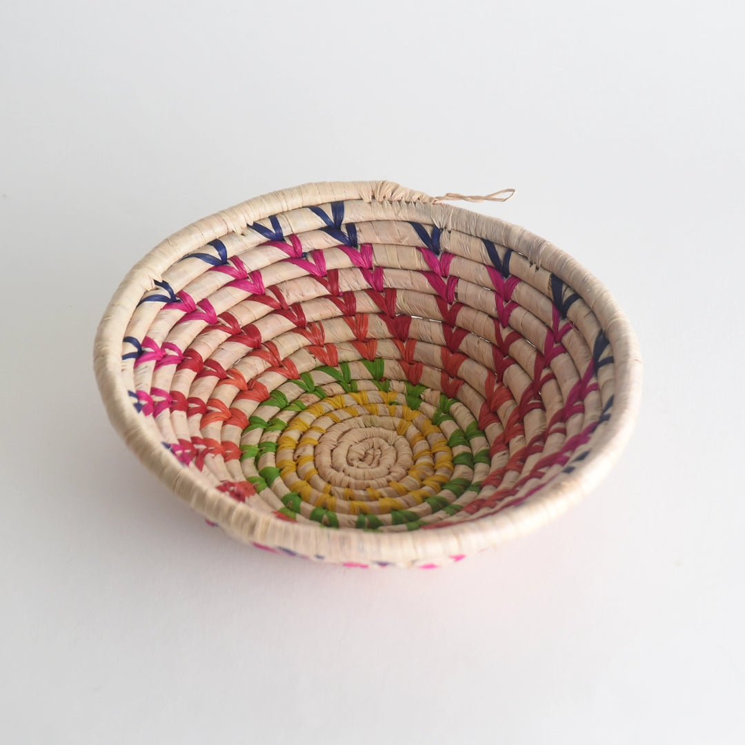 Woven basket with colorful pattern on a white background