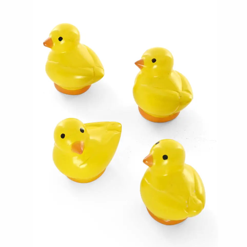 Four small yellow soapstone chick figures with orange beaks and orange bases, arranged on a plain white background.