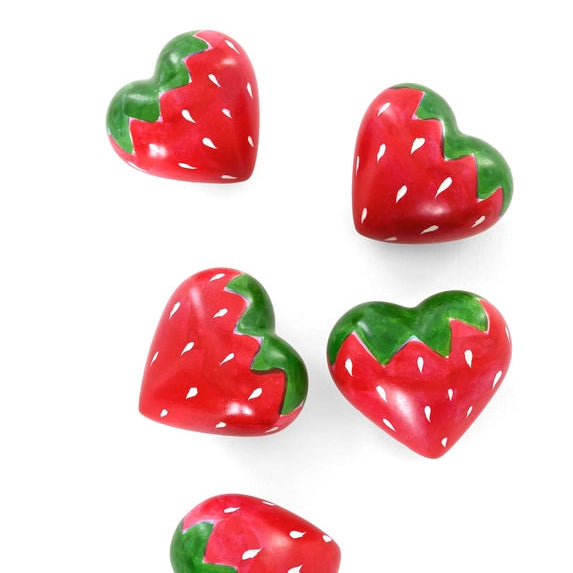 Five heart-shaped strawberry decorations on a white background