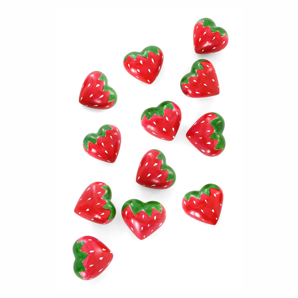 Ten heart-shaped strawberry soapstones scattered on a plain white background.