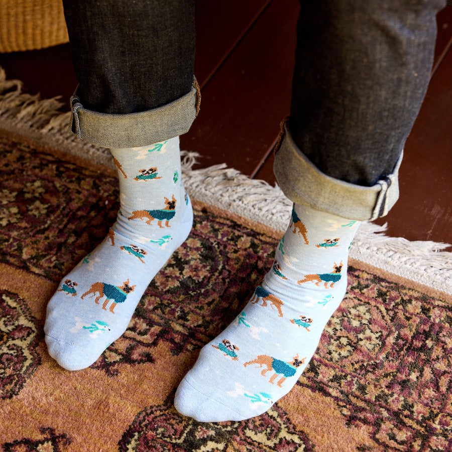 Person wearing white socks with dog patterns on a patterned rug