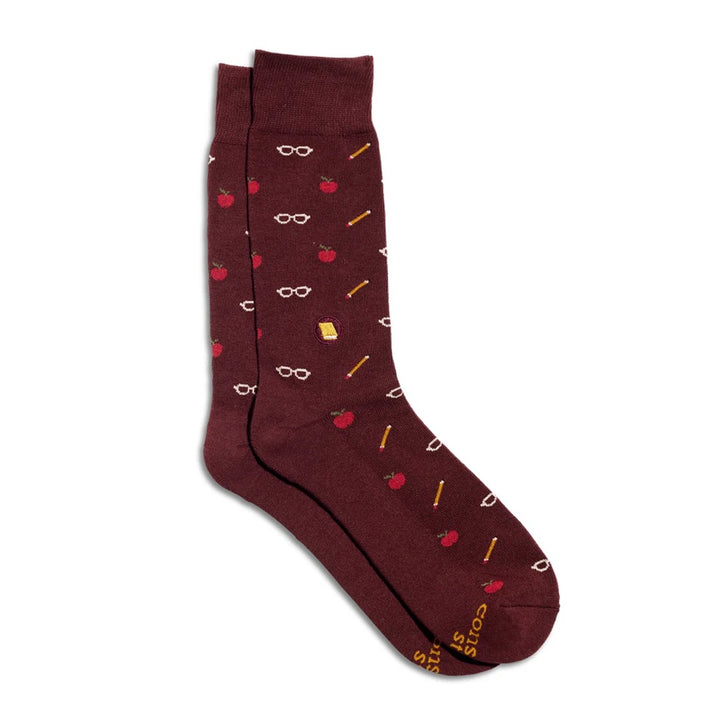 Burgundy crew socks with apples and pencils that give books on a white background