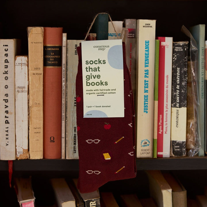 Burgundy crew socks with apples and pencils that give books. 