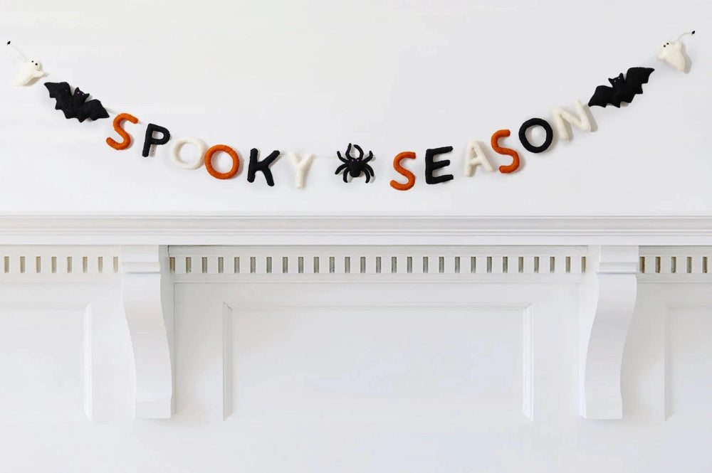 Halloween-themed decorative banner spelling 'Spooky Season' on a white fireplace.