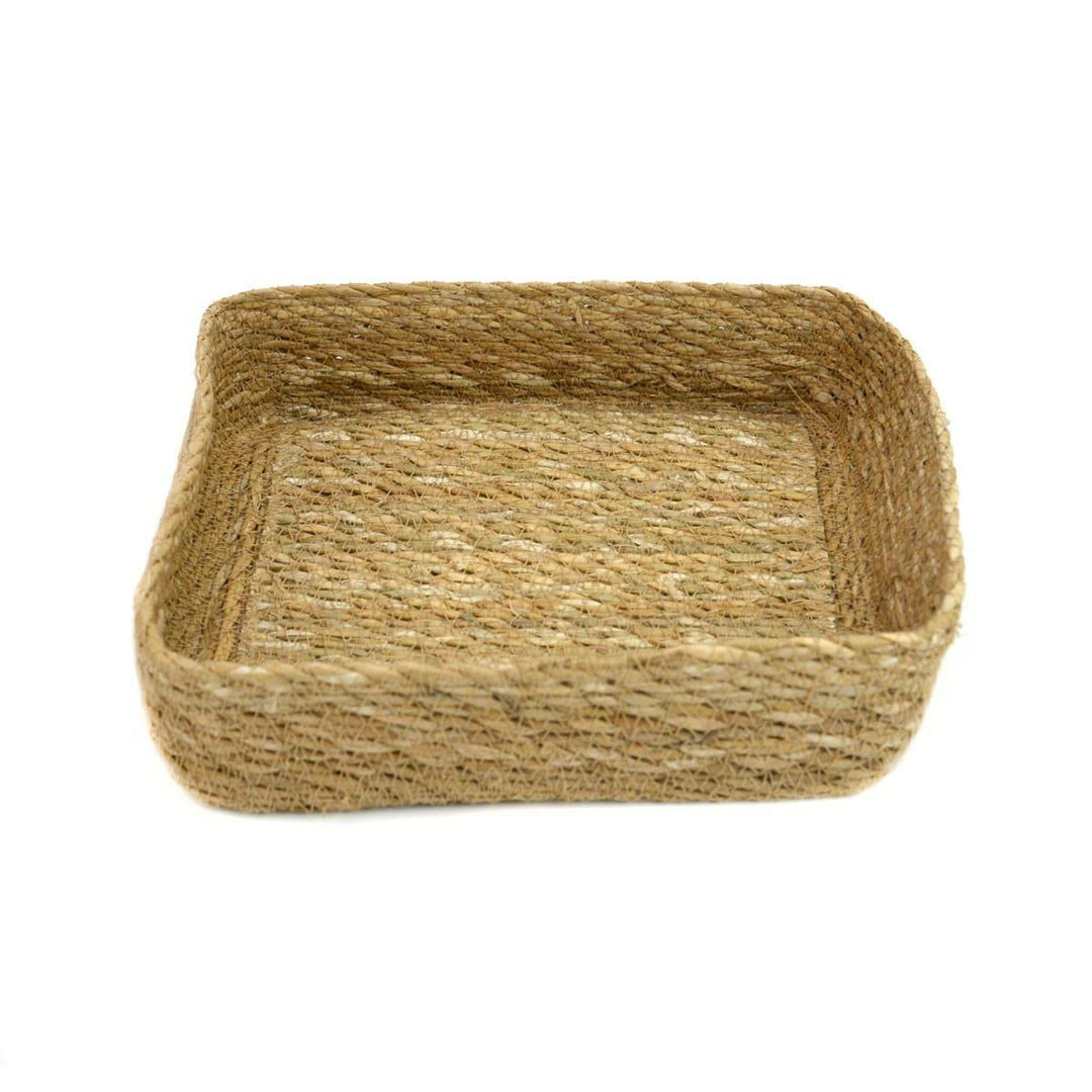 A square-shaped, brown seagrass basket with an open weave design.