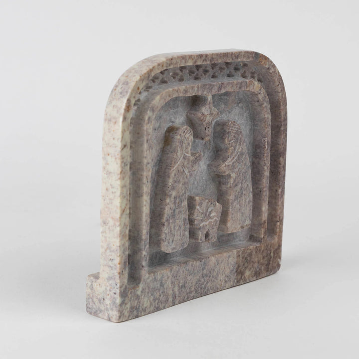 Decorative stone block with nativity carvings on a white background