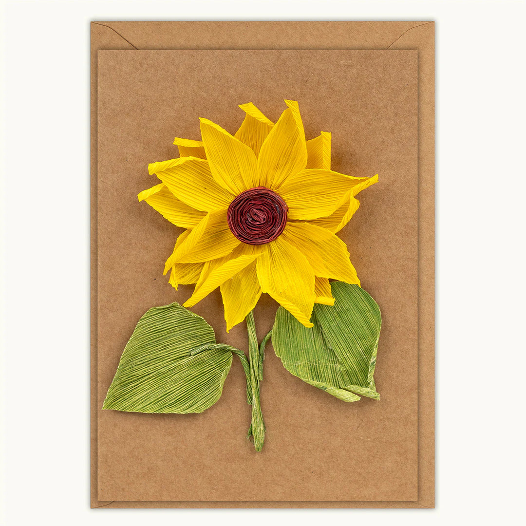 Yellow sunflower with green leaves on a brown card