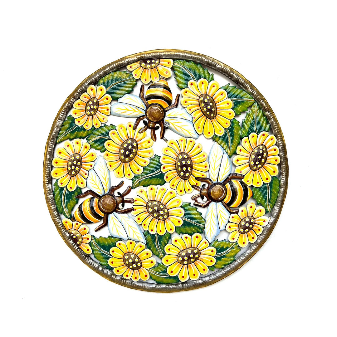 A round metal art featuring a hand-painted design of yellow sunflowers and three bees with green leaves, set against a plain white background.