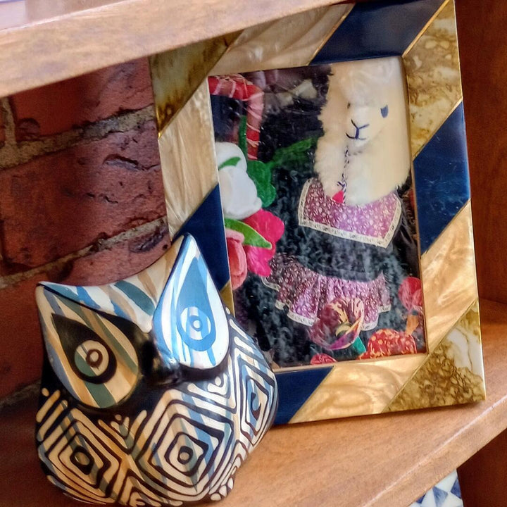 Decorative picture frame with a colorful striped pattern on a wooden surface.