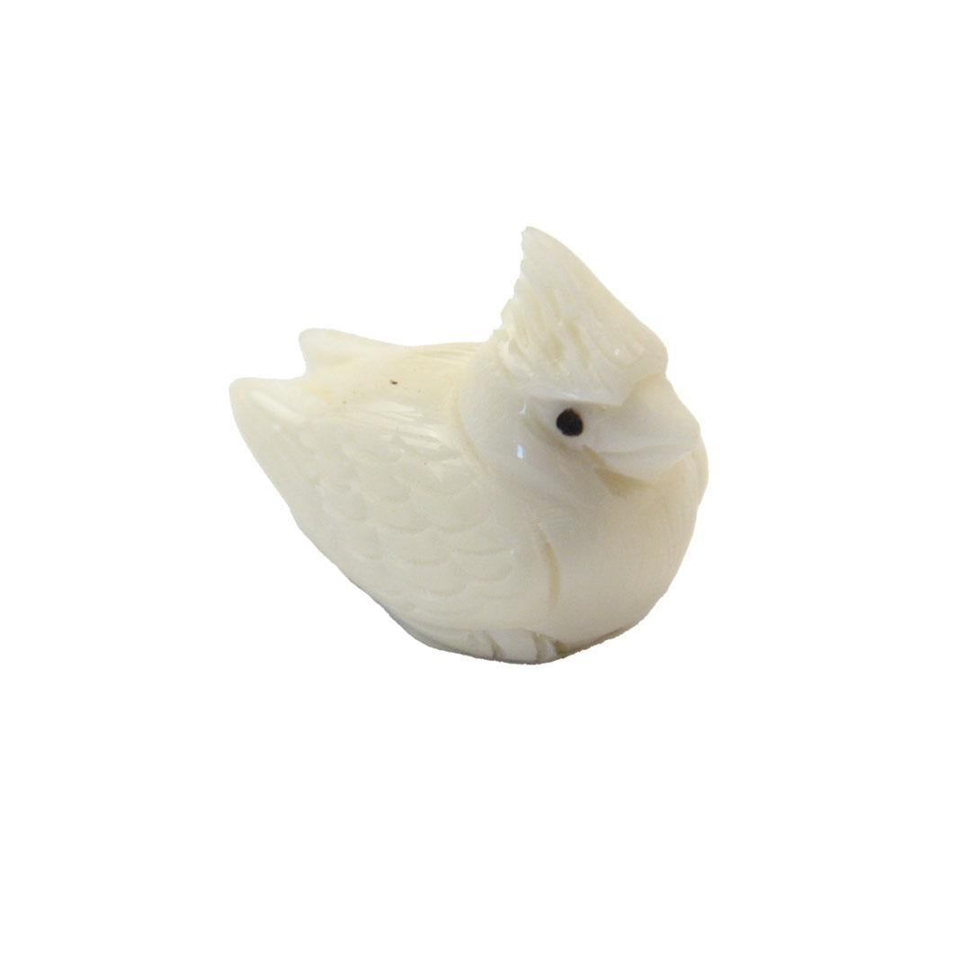 a hand carved tagua nut cardinal on a white background