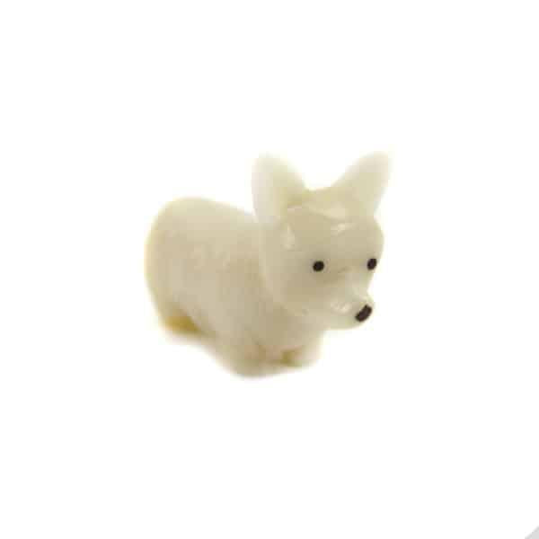 a hand carved tagua nut corgi on white background