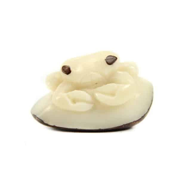 a hand carved tagua nut crab on a white background