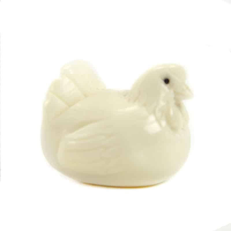 a hand carved tagua nut hen on a white background