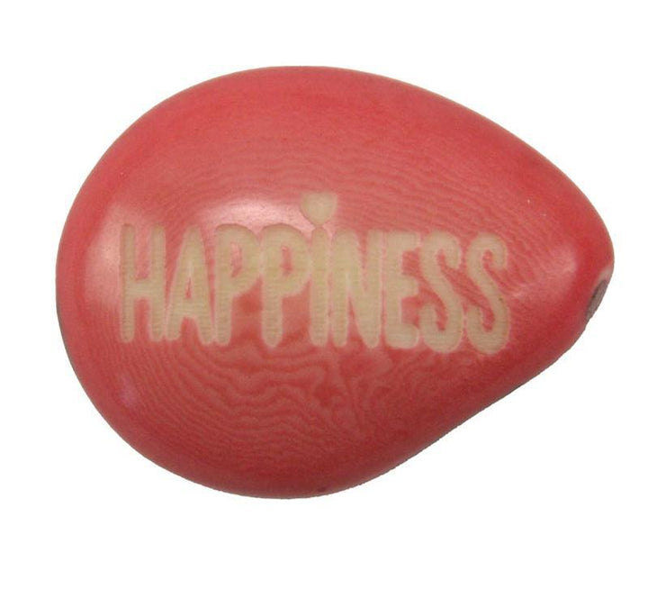 a pink tagua nut with the word 'happiness'