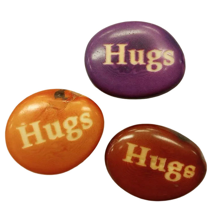 a collection of tagua nuts with word "hugs".