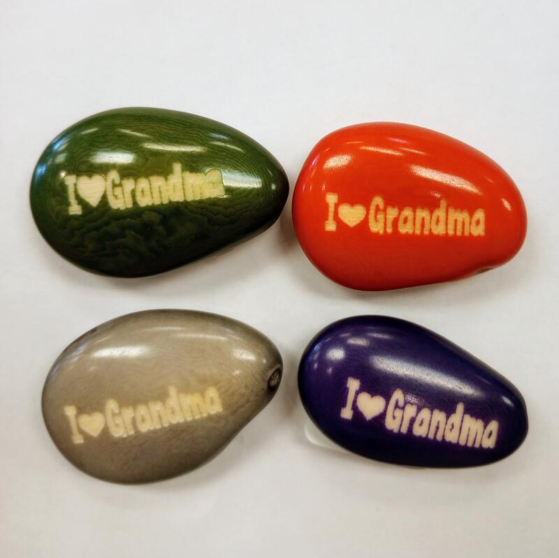 Four colorful tagua nuts with 'I ❤️ Grandma' text on a white background