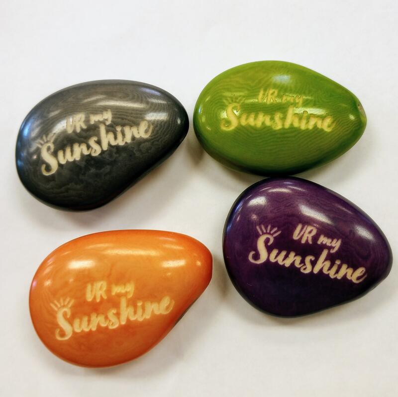 Four colorful tagua nuts with 'UR My Sunshine' text on a white background