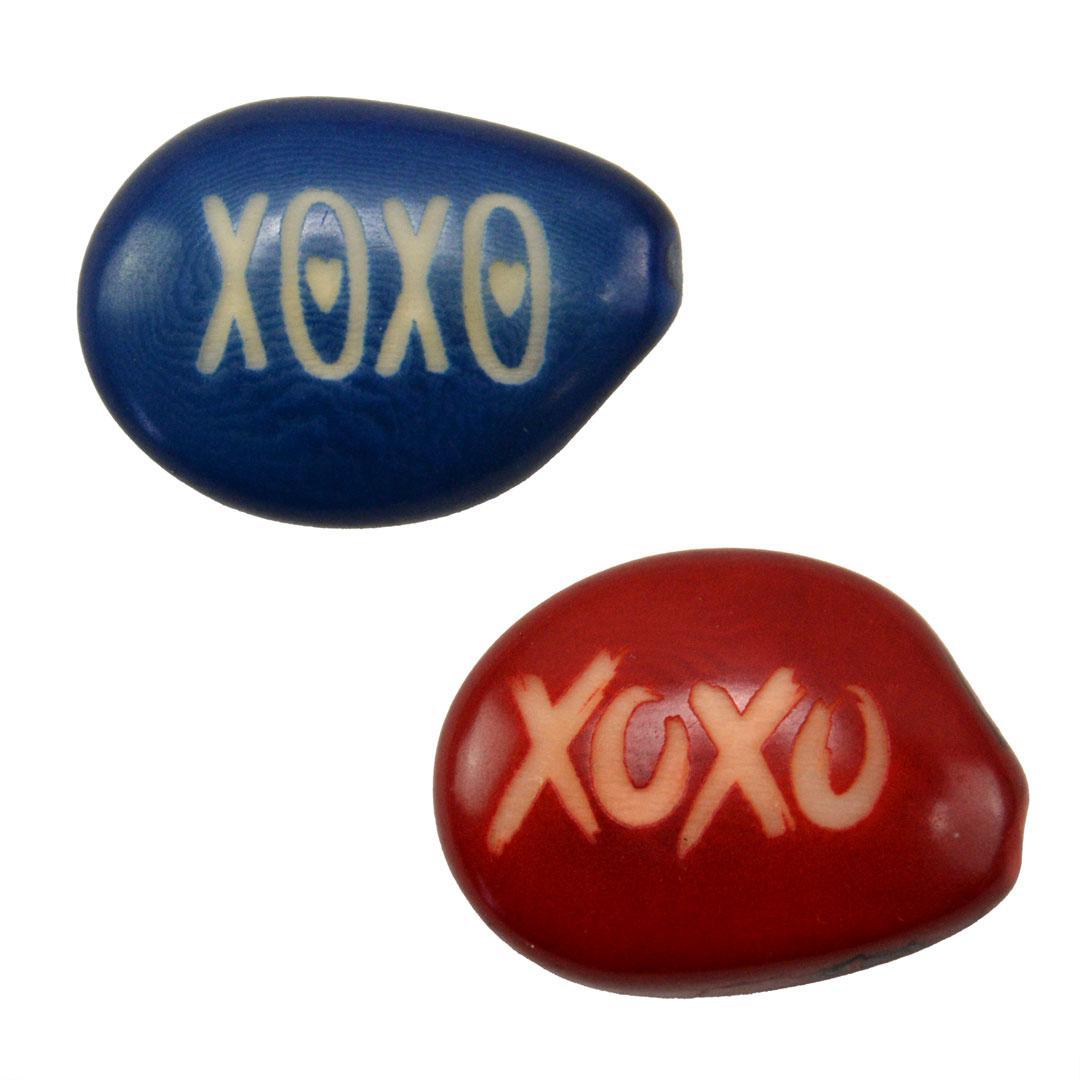 two tagua nuts with the letters xoxo