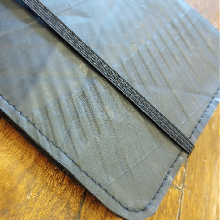 Close-up of a textured leather passport holder on a wooden surface
