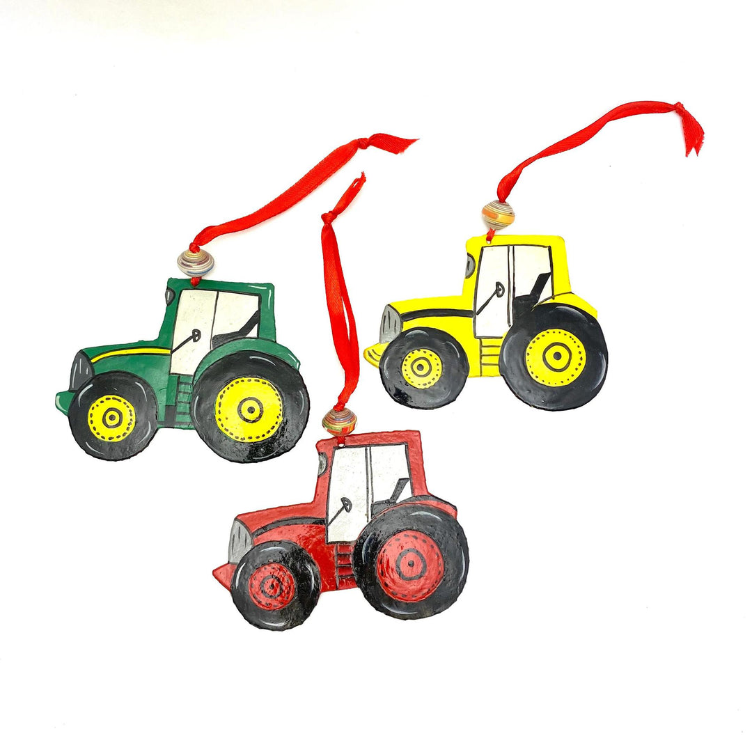 Red, green, and yellow tractor ornaments on a white background. 