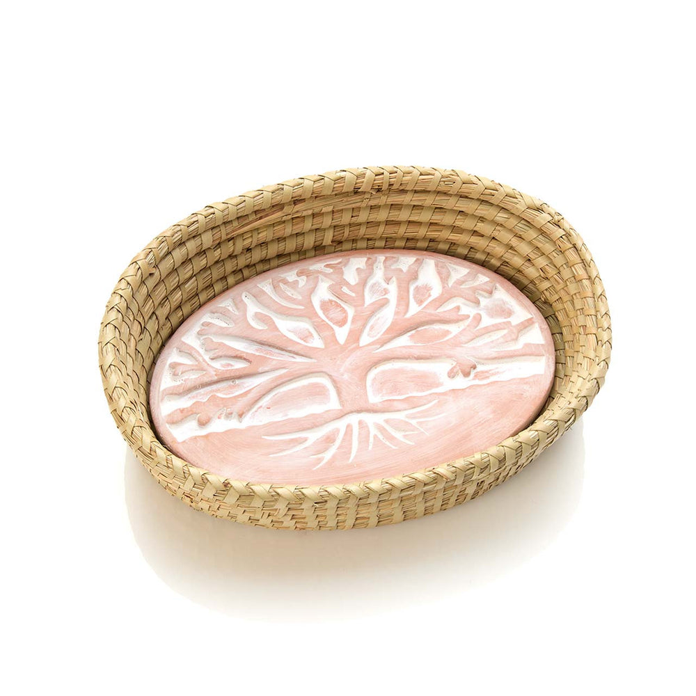 warming plate with tree design inside a woven basket on a white background