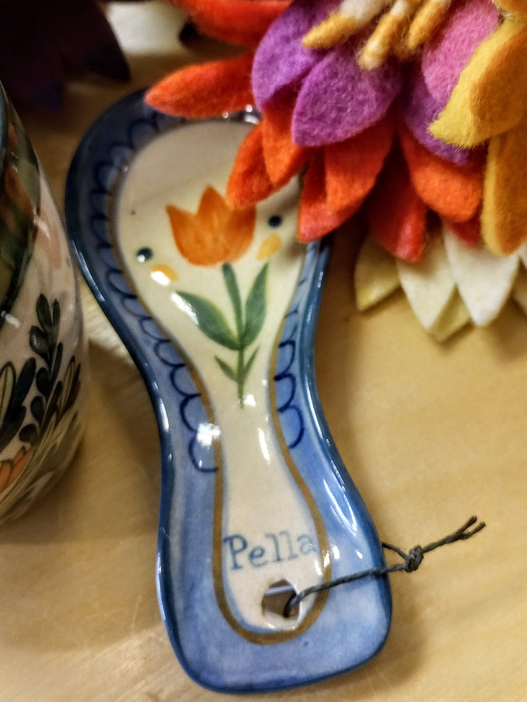 Decorative ceramic spoon rest with floral design and Pella 