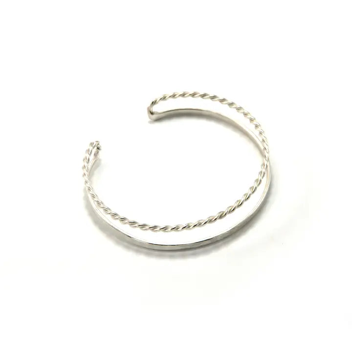 A silver-toned twisted open cuff bracelet on a plain white background.