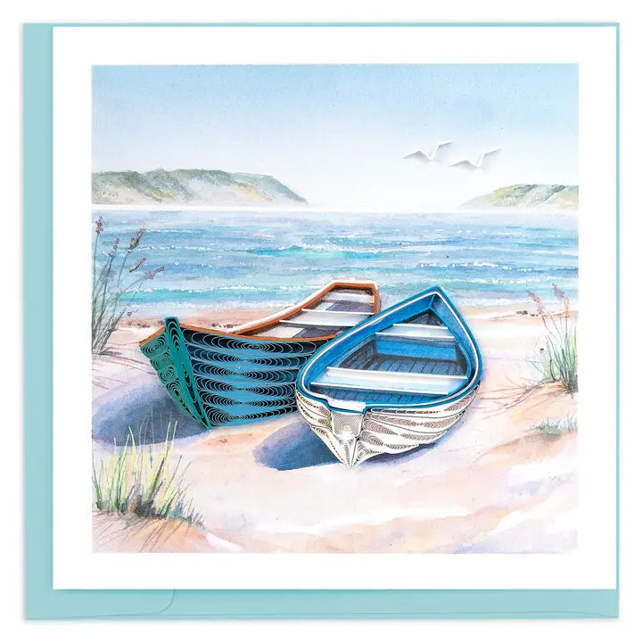Two boats on a sandy beach with a blue sky and ocean in the background