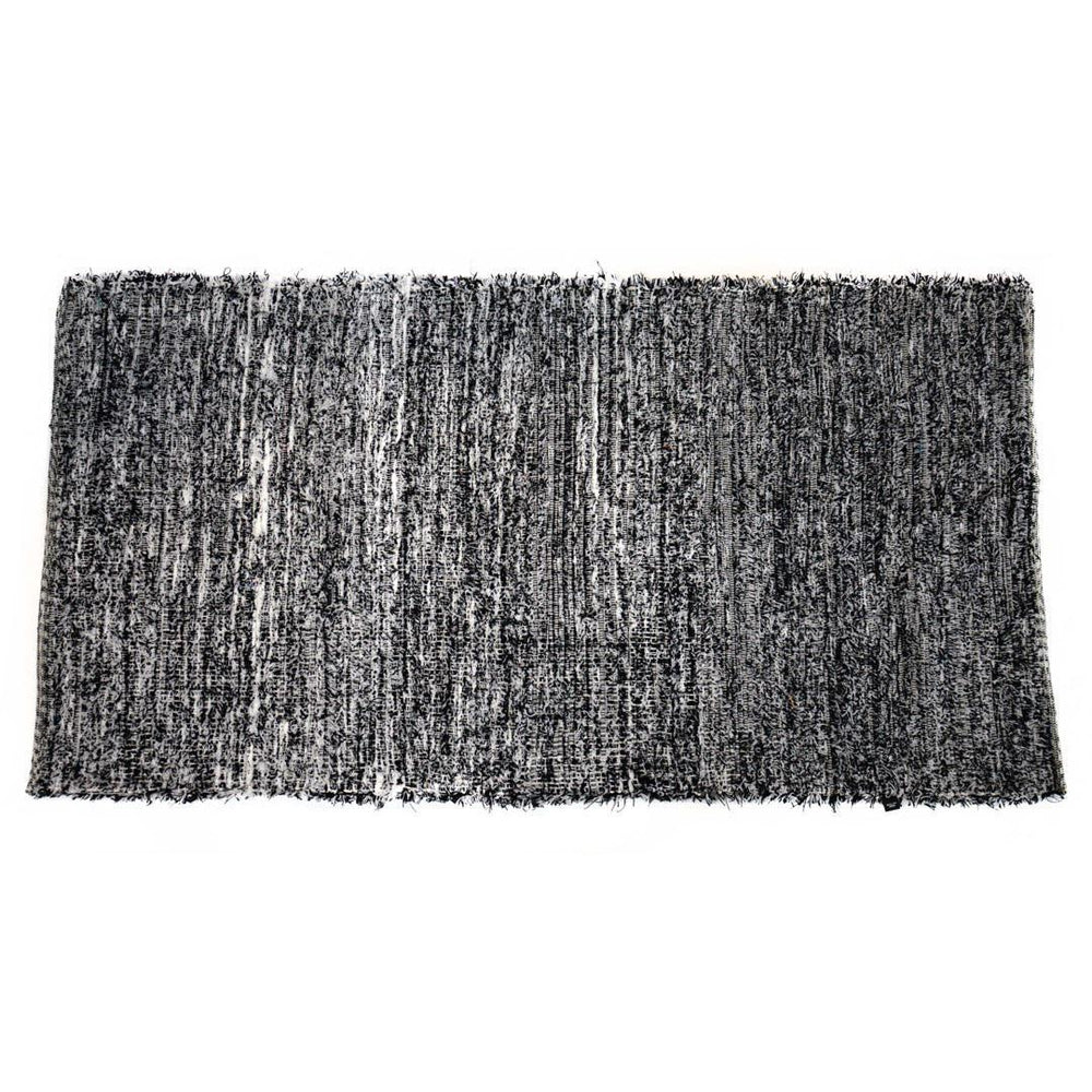 Black and white upcycled fabric rug on a white background.
