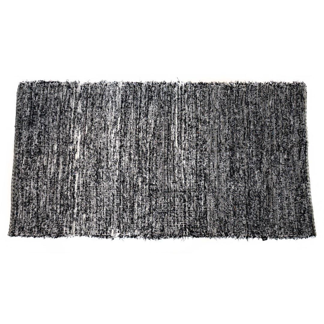 Black and white upcycled fabric rug on a white background.