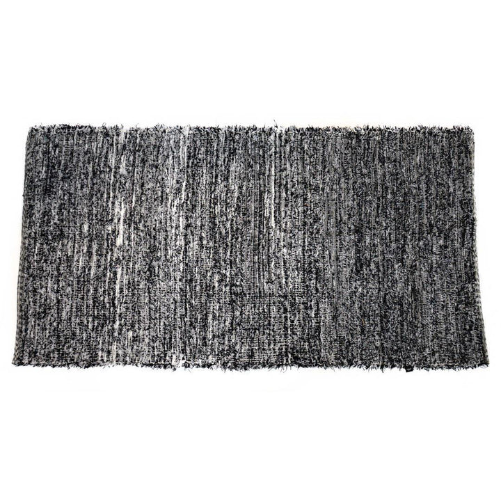 Black and white upcycled fabric rug on a white background.