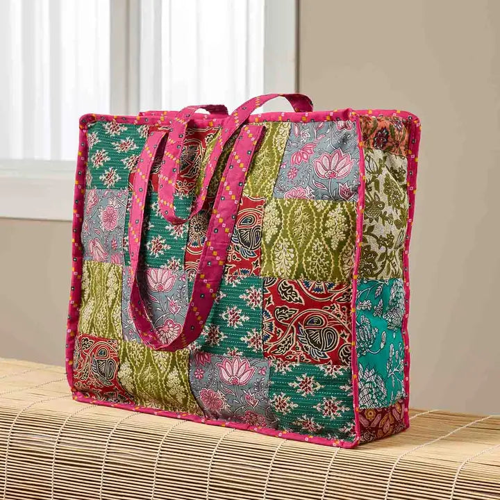 Colorful patchwork tote bag with floral and paisley patterns on a wooden surface.