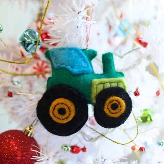 Handmade felt ornament in vehicle shape of green tractor.