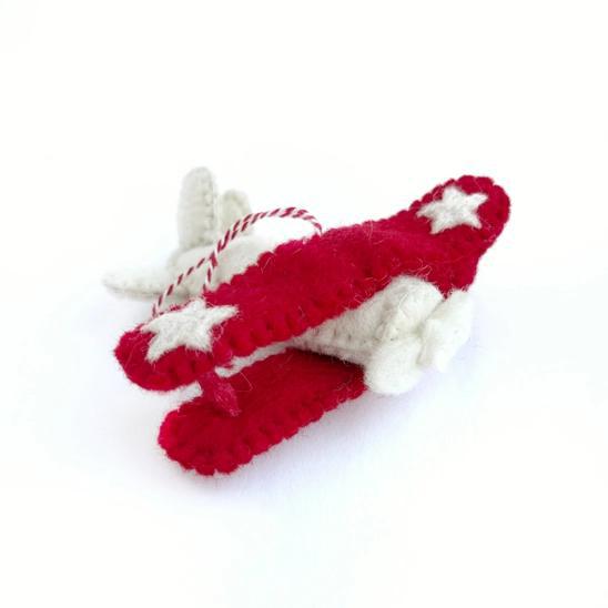 Handmade felt ornament in vehicle shape of red and white airplane.