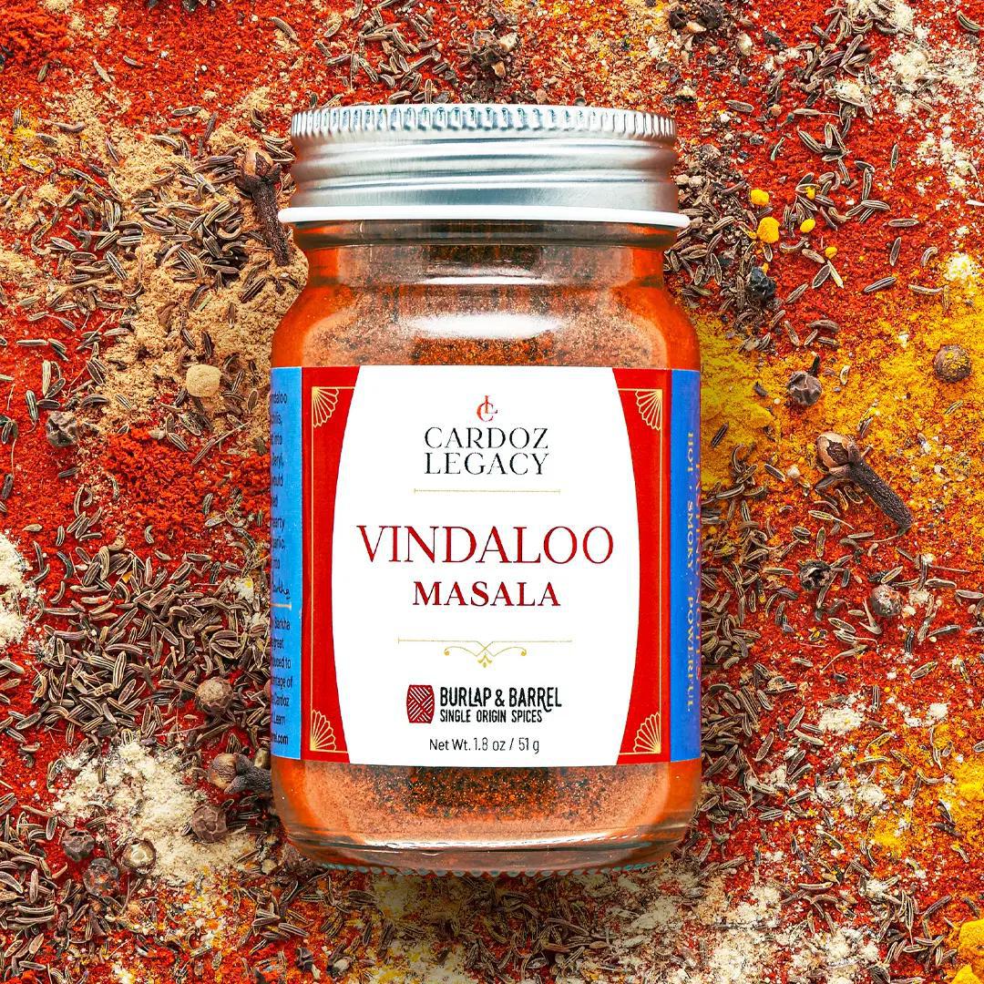 Jar of Vindaloo Masala spice mix with a visible brand label on a colorful background of spices.