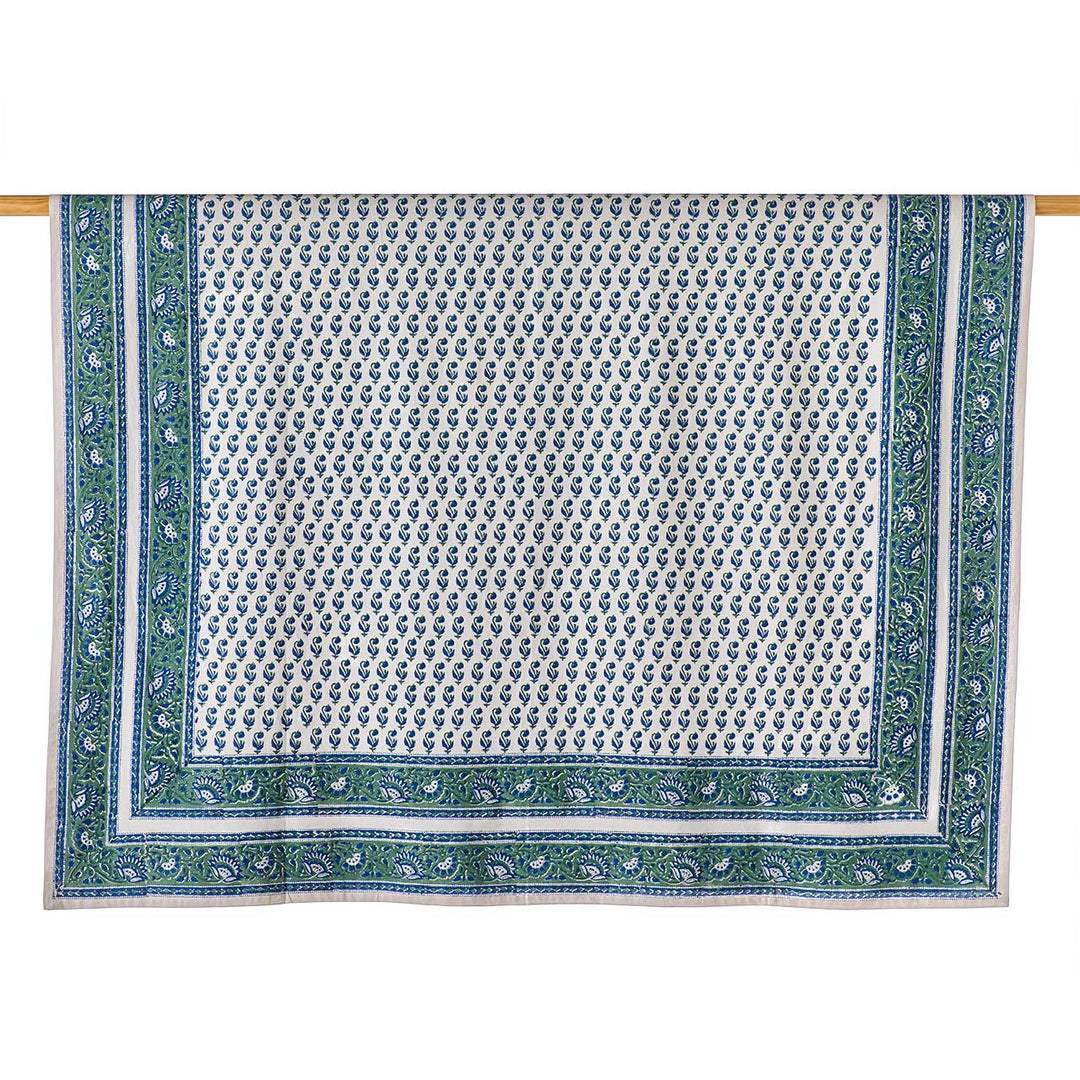 Decorative tablecloth with green border and white pattern on a white background