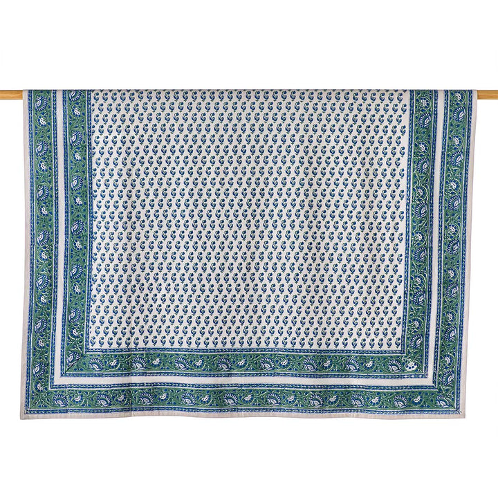Decorative tablecloth with green border and white pattern on a white background