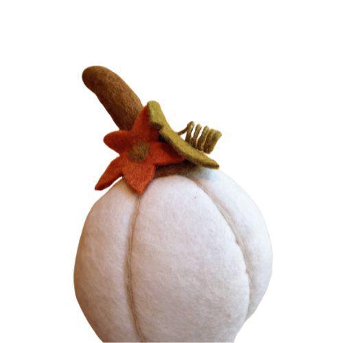 Handcrafted felt harvest pumpkin with a brown top and a flower, primarily white in color with beige details.