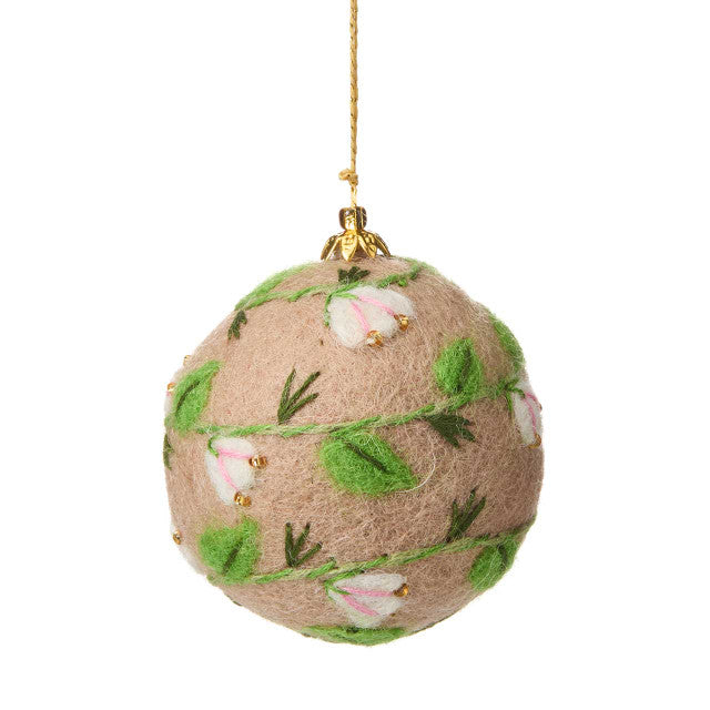 Decorative felt ball ornament with floral pattern on a white background
