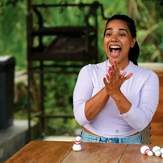 Woman clapping hands with a table and outdoor background