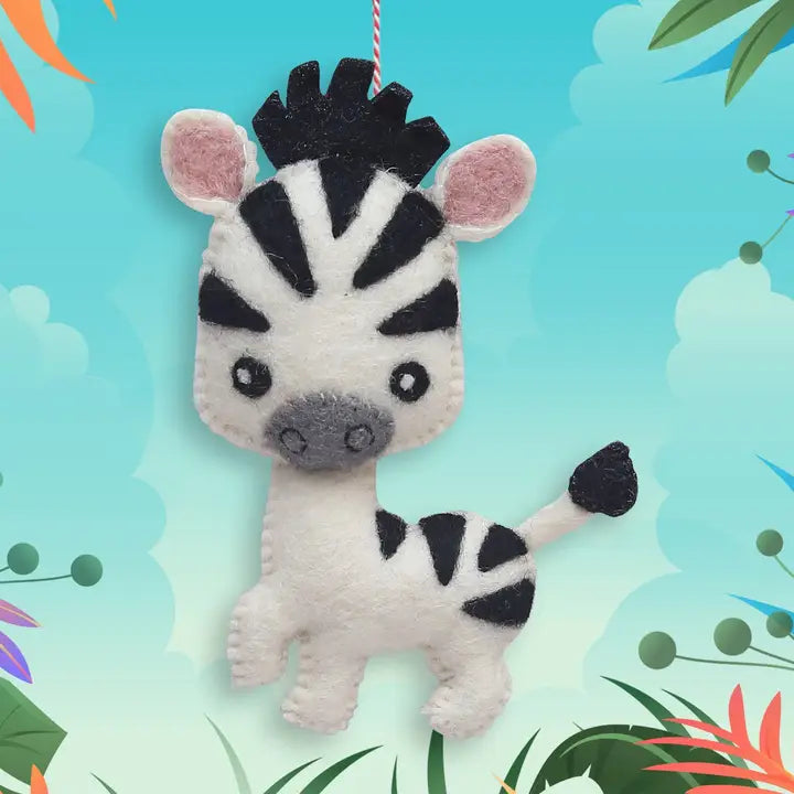 A cute felt zebra ornament hanging by a red string, set against a colorful tropical-themed background.