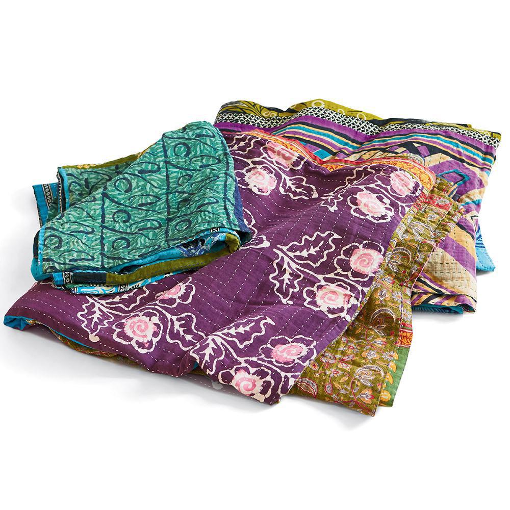 A kantha throw with multicolored patterns including purple, green, and pink, with floral and geometric designs.