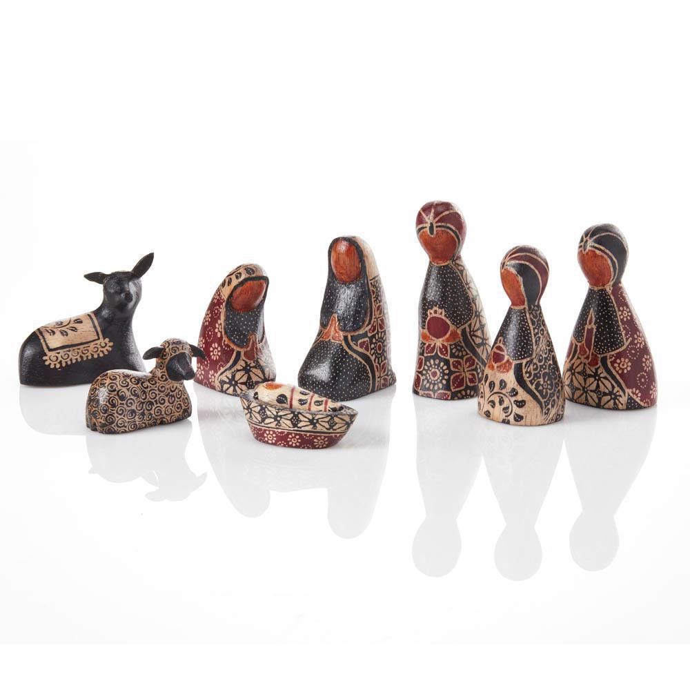 A nativity set with various figures, carved and painted with traditional Indonesian patterns in black, brown, and white tones.