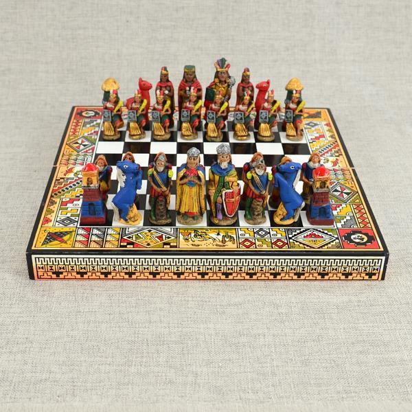A Peruvian chess set with hand painted wooden pieces on a colorful board that folds in half.