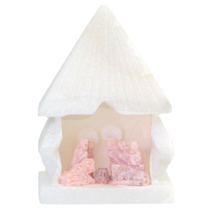Small nativity scene figurine with a roof carved from alabaster against a white background